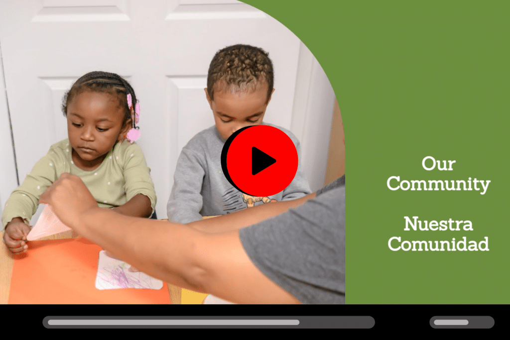Two young children do crafts at a table while an adult assists, with text: “Our Community Nuestra Comunidad.”.