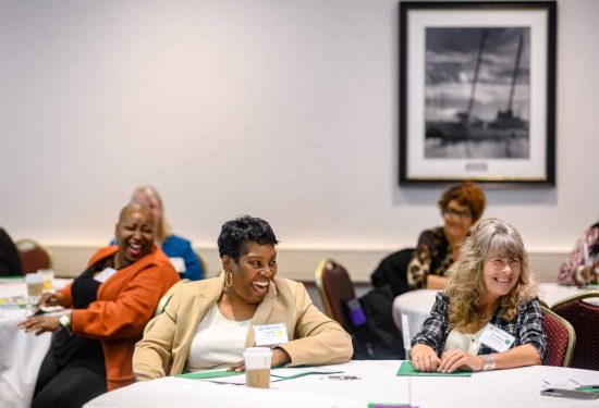 Home-based child care providers at a convening building community and learning about the latest updates in child care.