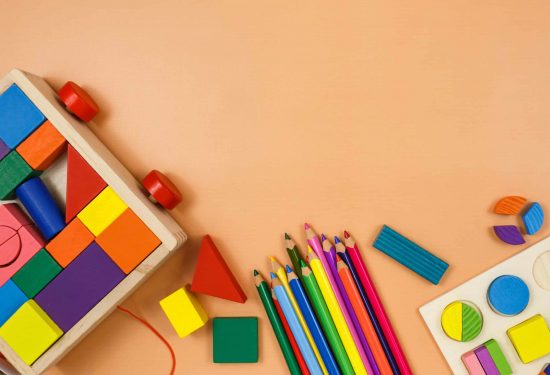 Colorful cubes, paints, pencils, blocks, modeling clay on orange background. Interesting math, games for preschool for kids. Education, back to school concept